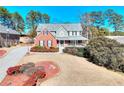 Beautiful two-story home with lush landscaping, long driveway, and classic architectural details at 3064 Zermatt Way, Snellville, GA 30078