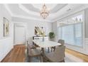 Elegant dining room featuring a chandelier, tray ceiling, and large windows at 2477 Misty Rose Ln, Loganville, GA 30052