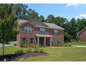 Traditional two-story brick home with manicured lawn and attractive landscaping, with a vibrant lawn at 1326 Harlequin Way, Stockbridge, GA 30281