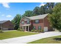 Classic brick home with an attached garage and long driveway nestled on a well-manicured lot at 1326 Harlequin Way, Stockbridge, GA 30281