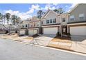 View of multiple townhomes with well-kept lawns along a tree-lined street at 2628 Wild Laurel Ct, Norcross, GA 30071