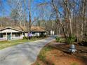 Single-story home with a long driveway, nestled among trees for added privacy at 901 Guys Sw Ct, Lilburn, GA 30047