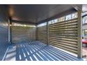 A modern-style carport providing shaded parking and privacy with its wooden slat wall and concrete flooring at 8744 Bellwood Ct, Riverdale, GA 30274