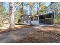 Charming home with a carport, featuring a split-level design, gray and white exterior, blue shutters, and a driveway at 8744 Bellwood Ct, Riverdale, GA 30274