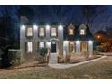 Well-lit home exterior showcasing a charming two-story brick facade with symmetrical windows at twilight at 3182 Glynn Mill Dr, Snellville, GA 30039