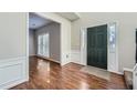 Inviting foyer featuring hardwood floors, wainscoting, and a view into the next room at 9185 Brockham Way, Alpharetta, GA 30022