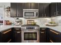 Close-up of kitchen with stainless steel oven, quartz countertops, and sleek black cabinets at 1418 Dresden Ne Dr # 355, Atlanta, GA 30319