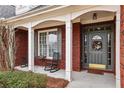 Inviting front porch with rocking chairs and gray front door, enhanced by brick detailing and white support columns at 172 Sweet Branch Ct, Grayson, GA 30017