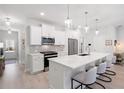Modern kitchen with white cabinetry, stainless steel appliances and a long island with stools at 3037 Ferrington Way, Smyrna, GA 30080