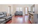 Bright living area showcasing hardwood flooring, a comfortable sofa, and a wall-mounted television at 570 Mcgarity Dr, Mcdonough, GA 30252