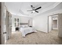 Spacious main bedroom with tray ceilings, a ceiling fan, and neutral-colored walls at 742 Eastwood Rise, Stone Mountain, GA 30087