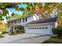 Side view of a charming two-story home with a large garage and well-maintained landscaping at 870 Richmond Hill Dr, Marietta, GA 30068