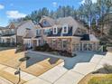 Charming two-story brick home with a well-manicured lawn, long driveway, and attached two car garage at 617 Oakbourne Way, Woodstock, GA 30188