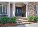 Elegant stone steps lead to a decorative double door framed by white columns and lush shrubbery at 2813 Long Grove Ct, Marietta, GA 30062