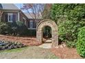 Beautiful landscaping with an stone archway and a path through lush greenery and colorful flowers at 2813 Long Grove Ct, Marietta, GA 30062