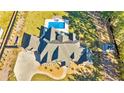 An aerial view of a well-maintained home with a pool, hot tub, and spacious backyard with mature trees at 650 New Morn Dr, Hampton, GA 30228