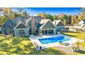 Beautiful backyard featuring a pool, spa, covered patio, and ample green space for outdoor enjoyment at 650 New Morn Dr, Hampton, GA 30228