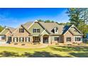 Charming exterior of a two-story home with a combination of stone and siding, and a well-manicured lawn at 650 New Morn Dr, Hampton, GA 30228