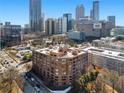 A high-angle, long shot of a beautiful brick building with city views and manicured trees surrounding at 115 W Peachtree Nw Pl # 602, Atlanta, GA 30313