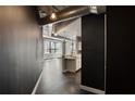 View into the kitchen, with a neutral island, view to the living space, exposed duct work, and dark floors at 115 W Peachtree Nw Pl # 602, Atlanta, GA 30313