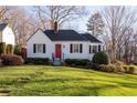 Cozy home with a red front door, classic black shutters, and lush green lawn at 255 Maple Nw Ave, Marietta, GA 30064