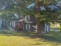 Nice two-story house featuring gray siding, white trim, and a red front door, surrounded by mature trees at 2710 Beaver Creek Xing, Powder Springs, GA 30127