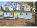 Charming renovated home featuring a bright yellow front door and freshly landscaped front yard and light blue painted brick at 2874 Horse Shoe Dr, Atlanta, GA 30316