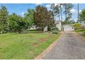 View of a one story home with a long driveway leading to a detached two car garage at 2107 Old Dallas Sw Rd, Marietta, GA 30064