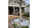 Landscaped front yard featuring daffodils and rocks at charming brick home at 3030 Appling Hills Dr, Dacula, GA 30019