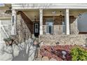 Inviting front porch featuring brick facade, columns, and stylish decor at 3030 Appling Hills Dr, Dacula, GA 30019