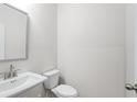 Small bathroom features a pedestal sink, toilet, and a large mirror at 1068 Rose Dr, Marietta, GA 30060