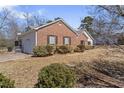 Side view of a beautiful brick house with a well-manicured lawn and mature landscaping at 1295 Brady Ct, Hampton, GA 30228