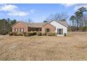 Charming brick home with a well-maintained lawn and mature landscaping in a suburban neighborhood at 1295 Brady Ct, Hampton, GA 30228