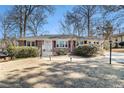 Charming brick home with manicured lawn, mature trees, walkway lighting and beautiful sunset backdrop at 1501 Sagamore Drive Ne Dr, Atlanta, GA 30345