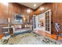 Sophisticated living room showcasing wood-paneled walls, hardwood floors, and french doors to the foyer at 2679 Wynnton Dr, Duluth, GA 30097