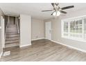 Bright living room with updated flooring, a ceiling fan, and a large window at 3390 Navaho Se Trl, Smyrna, GA 30080
