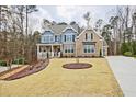 Beautiful two-story home with a manicured front lawn and large windows bringing in tons of natural light at 1496 Rocky River Dr, Lawrenceville, GA 30045