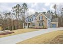 Stunning two-story home with long driveway and three-car garage in wooded lot at 1496 Rocky River Dr, Lawrenceville, GA 30045