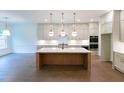 Modern kitchen featuring a large island, stainless steel appliances, and pendant lighting at 6490 Mockingbird Rd, Cumming, GA 30028