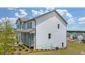 Bright, two-story home with white siding and a charming porch, nestled in a developing neighborhood with lush greenery at 3511 Summerlin Pkwy, Lithia Springs, GA 30122