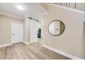 Inviting foyer with wood-look floors, a sliding barn door, an accent mirror, and access to the staircase at 3277 Bluejay Lane # 41, Alpharetta, GA 30022