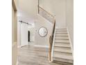 Bright foyer featuring a staircase with iron railings, a light gray accent wall, and wood-look flooring at 3277 Bluejay Lane # 41, Alpharetta, GA 30022