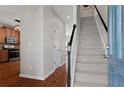 Inviting foyer featuring hardwood floors, staircase, and an open view into the kitchen at 3760 Lake Point Blvd, Suwanee, GA 30024