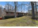 Home exterior featuring a brick facade, covered parking, and a well-maintained lawn at 3806 Lindley Cir, Powder Springs, GA 30127