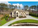 Elegant stone home boasts lush landscaping, a curved driveway, and a grand entrance with manicured greenery at 4434 Oglethorpe Nw Loop, Acworth, GA 30101