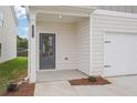 A well-lit front entrance with white columns, siding, and a two car garage at 2019 Wyndham Pl, Conyers, GA 30013