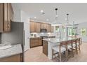 Open kitchen featuring a large island with seating, stainless steel appliances, and modern pendant lighting at 6094 Marigold Way, Atlanta, GA 30349