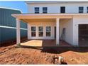 Covered patio with white support beams and large concrete floor, part of new construction home at , Conyers, GA 30094