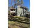 View of the back of the house featuring a large chimney and screened-in porch at 1677 Grey Fox Ct, Lawrenceville, GA 30044