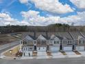 Aerial view of new townhomes displaying modern elevations, private garages, and professionally landscaped grounds at 3071 Greyton Dr, Buford, GA 30519